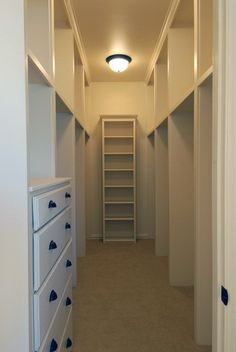 an empty walk in closet with shelves and drawers