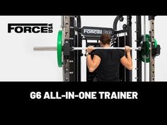 a man in black shirt holding a barbell on top of a gym machine