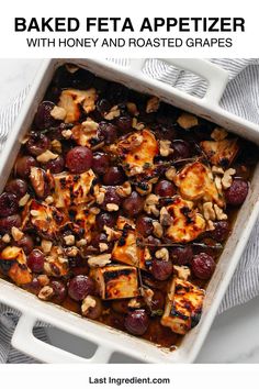 baked feta appetizer with honey and roasted grapes in a white casserole dish