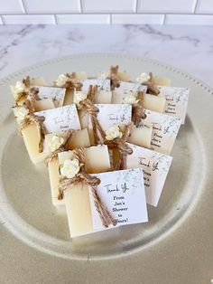 several pieces of soap sitting on top of a white plate with tags attached to them