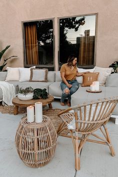 a woman sitting on top of a couch in front of a living room filled with furniture