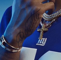 a close up of a person with a cross on his arm and some bracelets