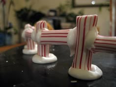 three red and white candy canes sitting on top of a table