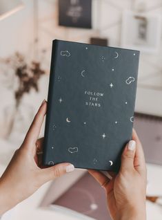 a person holding up a book with the words follow your stars written on it