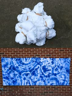 an aerial view of a blue and white object on the ground next to a brick wall