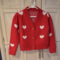 Here’s A Darling Cropped Cardigan That Will Take You Right Through Christmas And On To Valentine’s Day! From Chicwish And Brand New, It Is A Size Small In A Soft Acrylic Knit, Featuring Gold Heart Shaped Buttons Down The Front. The Background Of The Sweater Is A Deep Red, With White 2 Inch Wide Hearts Woven Into The Fabric. It Is Cropped, Measuring 20 Inches From Shoulder To Bottom Hem. The Shoulder Boasts A Slight Pleat, Offering The Puffed Look Of The Moment. What A Delightful Piece To Introdu Trendy Red Knit Cardigan, Cute Red Long Sleeve Cardigan, Cute Red Spring Cardigan, Cute Red Long Sleeve Sweater, Fitted Red Knit Cardigan, Cute Red Sweater For Fall, Play Closet, Cropped Knit Cardigan, Alice Costume