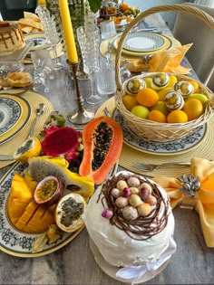 the table is set with plates, bowls, and baskets of fruit on it's sides