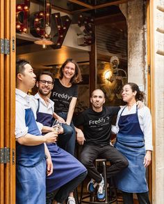 a group of people standing around each other in front of a restaurant