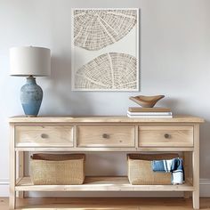 a wooden table with baskets underneath it and a painting on the wall in the background