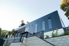 the house is made of concrete and has black shutters