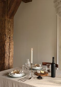 a table set for two with plates and wine glasses