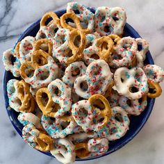 a blue bowl filled with sprinkles and pretzels