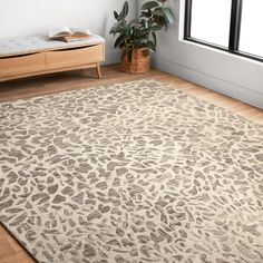 a large rug with an animal print pattern on it in a room next to a window