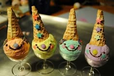 three ice cream sundaes with funny faces and stars on them, sitting in wine glasses