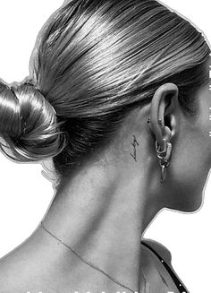 a black and white photo of a woman with tattoos on her neck