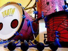 two drums are sitting next to each other in front of a spider - man drum