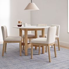 a dining room table with chairs and a lamp