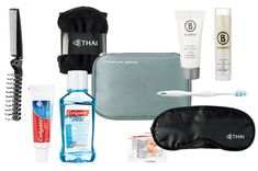 the contents of a travel kit including an electric toothbrush, mouthwash and eye mask