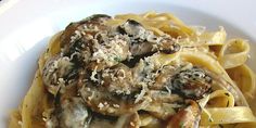 pasta with mushrooms and parmesan cheese in a white bowl