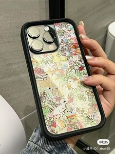 a woman holding an iphone case with pokemon drawings on it