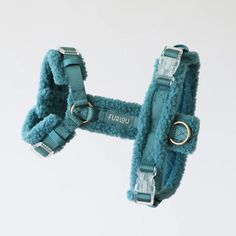 a blue dog harness with two rings on it's sides and the words fuggi written in gold