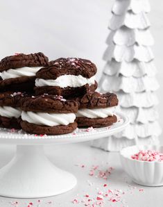 chocolate cookies with white frosting and sprinkles on a cake platter