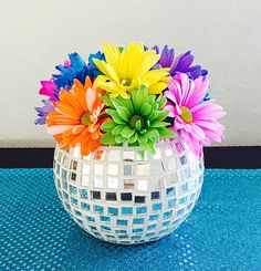 a vase filled with colorful flowers on top of a blue table