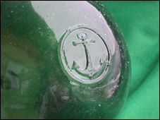 an anchor on the side of a green bottle