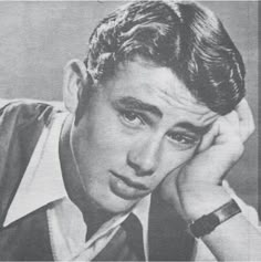 an old black and white photo of a young man with his hand on his head