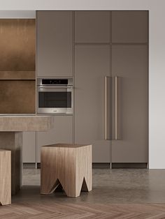 a modern kitchen with stainless steel appliances and wooden stools in the middle of the room