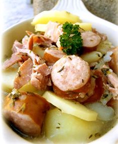 a white bowl filled with meat and vegetables