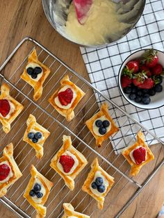 small pastries on a cooling rack with strawberries and blueberries