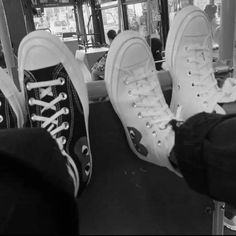 black and white photograph of two people's feet with converse shoes