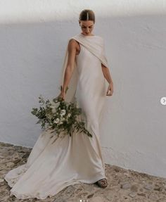 a woman in a white dress holding a bouquet