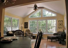 a living room filled with furniture and a ceiling fan in the middle of an open floor plan