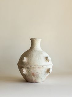 a white vase sitting on top of a table