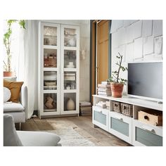 a living room filled with furniture and a flat screen tv sitting on top of a wooden floor