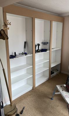 an empty room with some shelves in the middle and tools on the floor next to it