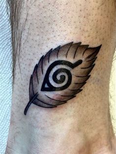 a tattoo with an eye and feather on the side of the foot, which has a spiral