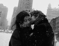 a man and woman kissing in the snow