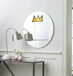 there is a mirror with a crown on it and a lamp next to the mirror