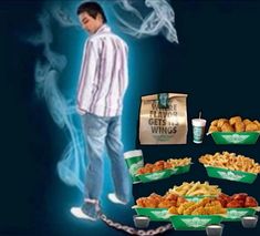 a man standing in front of several trays of food and a bag of fries