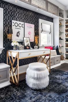 a dressing room with a vanity, stool and large mirror on the wall next to it