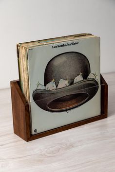 a book with an image of a hat and birds on it sitting on a wooden stand