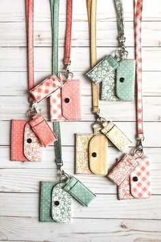 several different colored tags hanging on a white wall with wood planks and wooden boards in the background