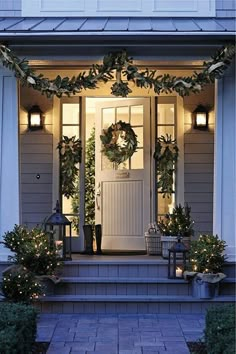 the front door is decorated with wreaths and lights