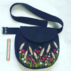 a blue purse with flowers and grass on it