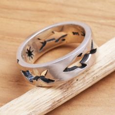 Stylish shark figures traverse a silver sea their movements illuminated by delicately etched stars. Made Sriasih creates this ring with a sense of modern design. .925 Sterling silver