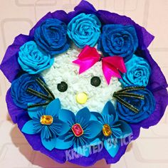 a cake made to look like a kitty with blue flowers on it's head