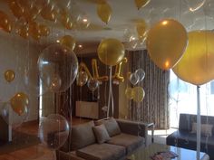 balloons are floating from the ceiling in this living room